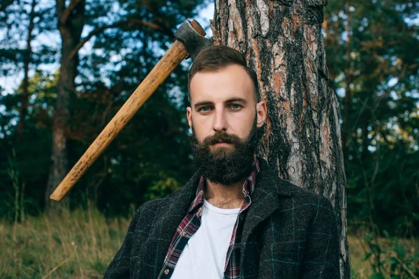 Porträt brutaler bärtiger und schnurrbärtiger Holzfäller Hipster-Zigeuner im Wald mit Axt — Stockfoto