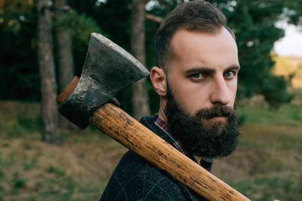 Retrato brutal barbudo e bigode lenhador hipster cigano homem na floresta com machado — Fotografia de Stock