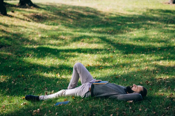 Homem barbudo deitado na grama — Fotografia de Stock