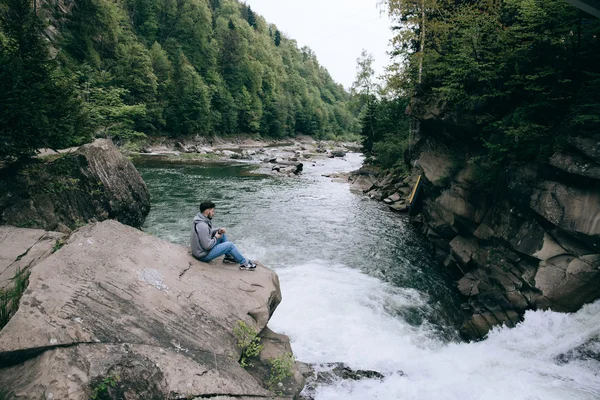 Hombre sentado en el hermoso río de montaña —  Fotos de Stock