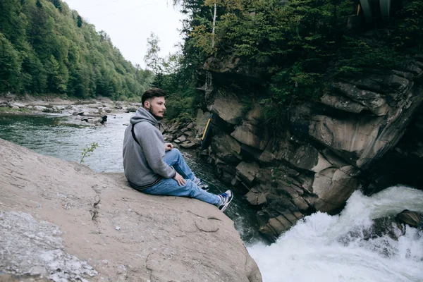 Hombre sentado en el hermoso río de montaña —  Fotos de Stock