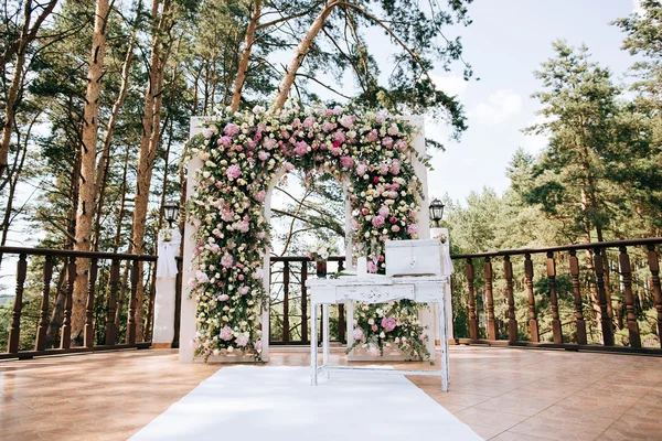 Arco per la cerimonia nuziale, decorato con fiori freschi in una pineta — Foto Stock