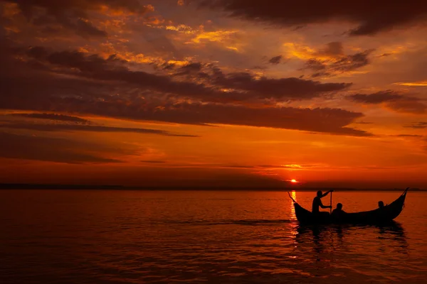 Persone di silhouette e barca sul mare del tramonto — Foto Stock