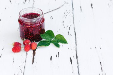 ahşap masa üzerinde bir kavanoza Ahududu reçeli