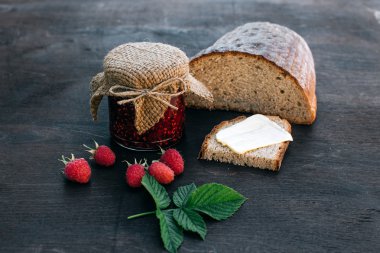 Öğle yemeği kahvaltısı. Kavanozda ahududu reçeli ve tereyağlı ekmek.