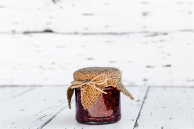 ahşap masa üzerinde bir kavanoza Ahududu reçeli