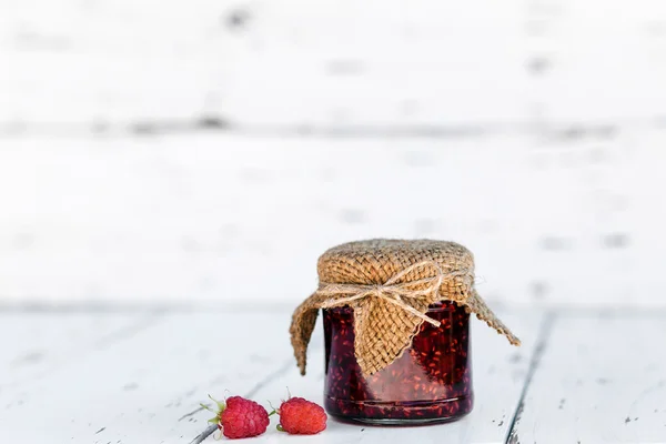 Selai raspberry dalam stoples di atas meja kayu — Stok Foto