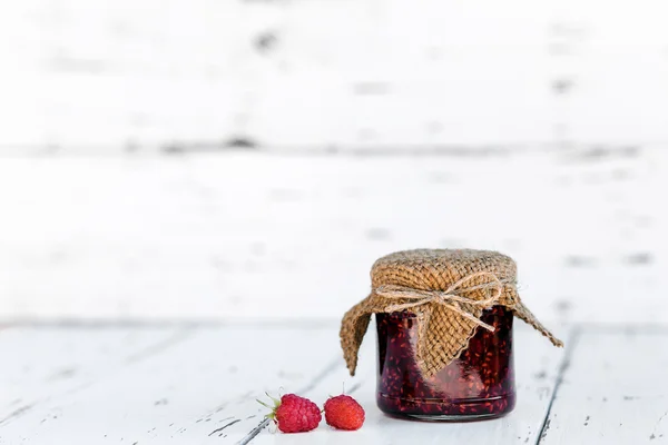 Confiture de framboises dans un bocal sur la table en bois — Photo