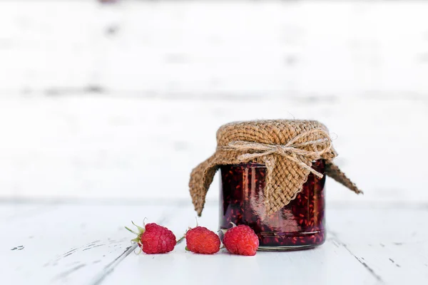Selai raspberry dalam stoples di atas meja kayu — Stok Foto