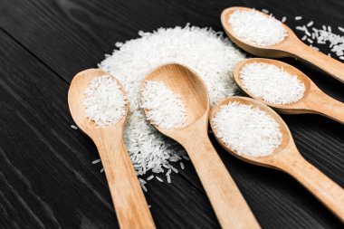 çiğ pirinç siyah masada tahta kaşıkla