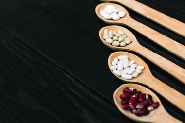 Renkli ahşap arka plan ağaç kaşık içinde fasulye