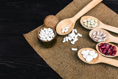 Renkli ahşap arka plan ağaç kaşık içinde fasulye