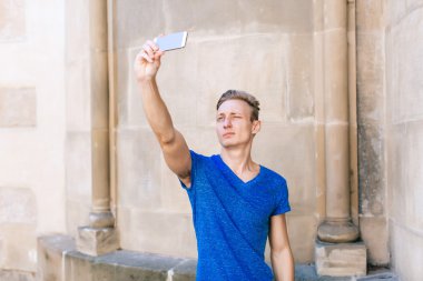 Mobil bir kentsel bağlamda bir selfie alarak kısa saçlı genç yakışıklı adam