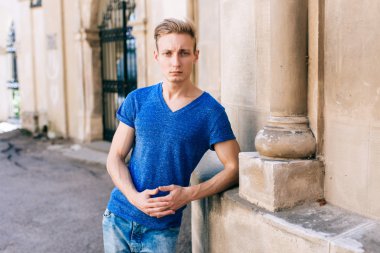 Çekici mavi gözlü, sarışın genç adam sokakta