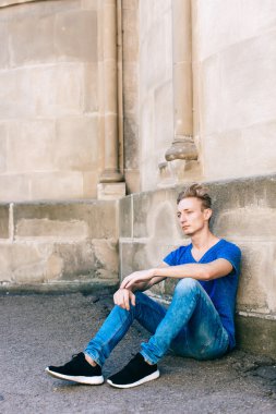 Çekici mavi gözlü, sarışın genç adam sokakta