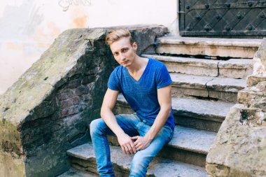 Çekici mavi gözlü, sarışın genç adam sokakta