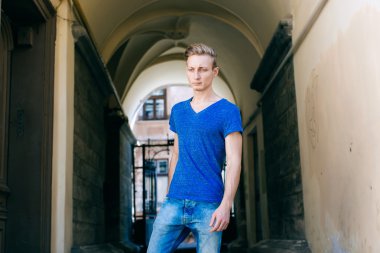 Çekici mavi gözlü, sarışın genç adam sokakta