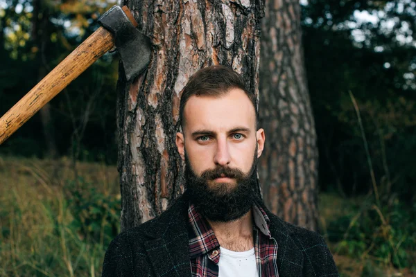 Portrait brutal hipster barbu homme dans la forêt avec hache — Photo