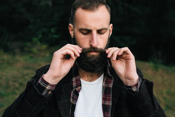 Ritratto brutale barbuto hipster uomo nella foresta con ascia — Foto Stock