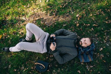 Portre acımasız sakallı hippi hayalperest fotoğrafçı adam eski film kamera ile ormanda