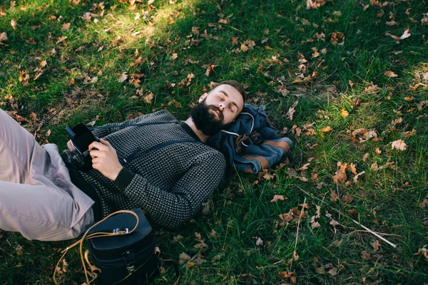 Ritratto brutale barbuto hipster sognatore fotografo uomo nella foresta con vecchia macchina fotografica — Foto Stock