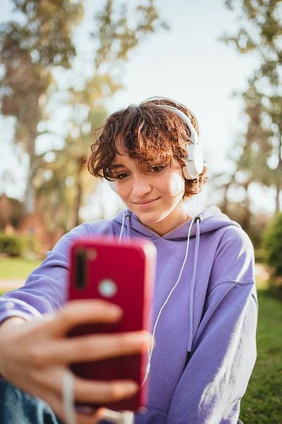 Mladá Dívka Bere Selfie Parku Používá Sluchátka Mobilní Telefon Poslouchá — Stock fotografie