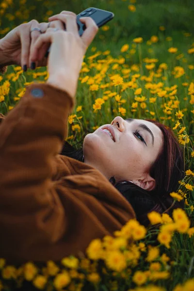 Teenager Dívka Relaxovat Trávě Pokryté Květinami Používá Chytrý Telefon Aby — Stock fotografie