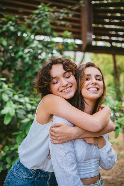 Two Young Teenager Girls Hugging Each Other Smiling Surrounded Plants — Stock Photo, Image