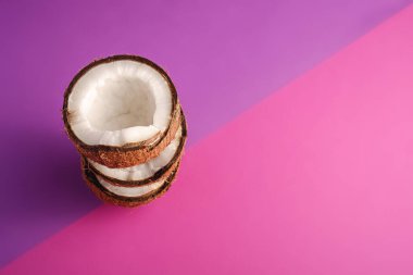 Menekşe ve mor arkaplan üzerinde istiflenmiş hindistan cevizi meyveleri, soyut gıda tropikal konsepti, açı görünümü kopyalama alanı