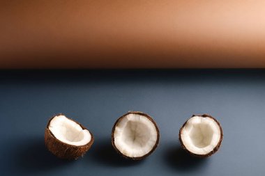 Kahverengi ve mavi katlanmış kağıt zemin üzerinde hindistan cevizi meyveleri, soyut gıda tropikal kavramı, açı görünümü kopyalama alanı