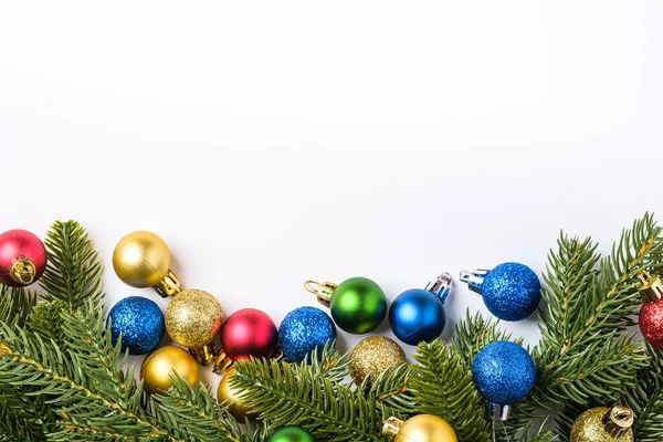 Kopya alanı olan bir Noel kompozisyonu. Renkli süsler, mücevherler ve köknar iğneleri, üst manzara