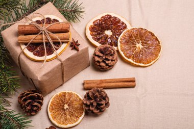 El yapımı Kraft kağıt hediye kutusu, kurutulmuş narenciye dilimleri, tarçın, anason, çam kozalakları ve köknar ağacı dalları ile Noel kompozisyonu.