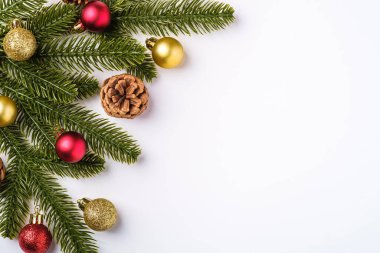 Kopya alanı olan bir Noel kompozisyonu. Renkli süsler, mücevherler ve köknar iğneleri, üst manzara