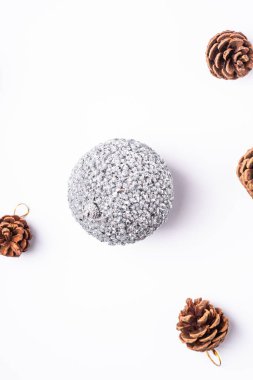 Yeni yıl kompozisyonu. Hediyeler, köknar ağacı konileri, beyaz arka planda gümüş top süslemeleri. Kış tatili konsepti. Düz yatış, üst görünüm