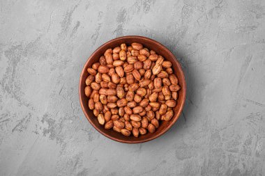 Beton arka planda ahşap kasede fındıklar, doğal sağlıklı vejetaryen yemekleri, üst manzara.