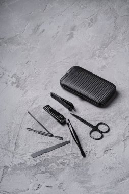 Manikür seti, pedikür aletleri ve çantalı aksesuarlar, taş beton arka plan, açı görünümü