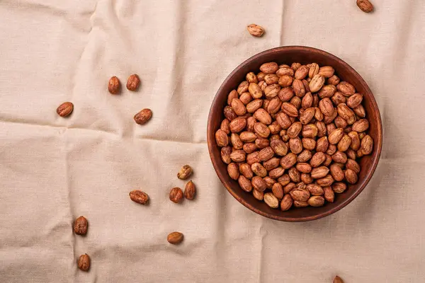 Ahşap kasede fındıklar keten kumaş arka planda, doğal sağlıklı vejetaryen yemekleri, üst manzara.