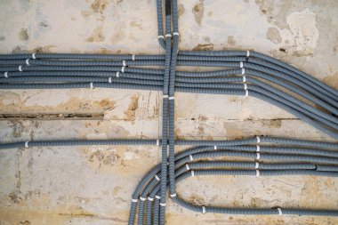 Electric cables in plastic tubes on ceiling, indoor renovation concept