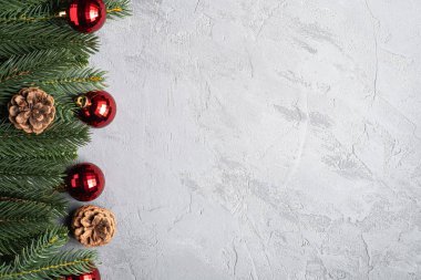 Noel tatili kompozisyonu. Kırmızı süs ve takı süsleri, köknar ağacı ve çam kozalakları. Boşluğu kopyala