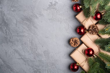 Noel tatili kompozisyonu. Kırmızı süs ve takı süsleri, köknar ağacı, hediyeler ve çam kozalakları. Boşluğu kopyala