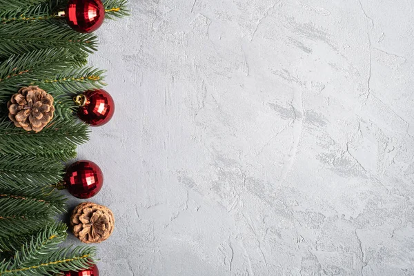Noel tatili kompozisyonu. Kırmızı süs ve takı süsleri, köknar ağacı ve çam kozalakları. Boşluğu kopyala
