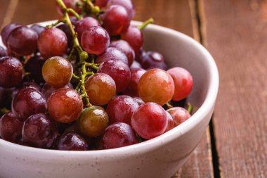 Kahverengi ahşap arka planda olgun üzüm üzümleri, açı açılı makro.