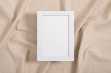 Bej bir tekstil üzerinde beyaz resim çerçevesi modeli