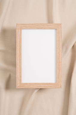 Ahşap çerçeve, bej bir tekstil üzerine beyaz bir model.