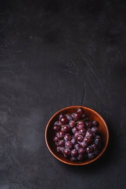 Taze üzüm üzümleri kahverengi ahşap kasede koyu taş arka planda, açı görünümü kopyalama alanı