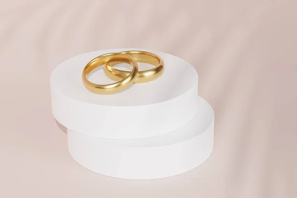 白い表彰台や台座の上に2つの黄金の結婚指輪 葉の影とベージュの背景 3Dレンダリング — ストック写真