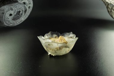 Siyah kaselerde depolanmış, tamamen katmanlı beyaz ve yeşil küf dokularıyla kaplı patateslerin üçgen şeklinde üst üste dizilmiş hali..