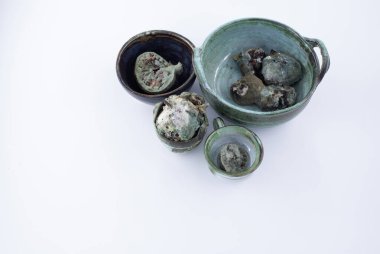 Küf, çürüme ve mantar kontaminasyonundan etkilenmiş kuru incir içeren birkaç seramik kase yemek bozma teması için beyaz arka planda fotoğraflanmış..