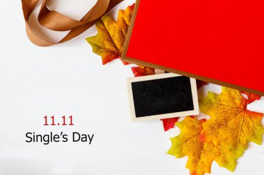 Çin 'de online alışveriş, 11.11 single' ın günlük satış konsepti. Metin ve akçaağaç yaprağı için mini karatahta, beyaz arka planda 11.11 bekar günü indirimi var..