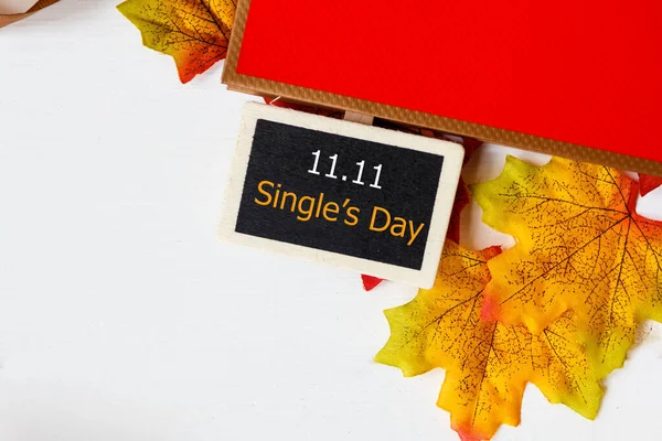 Online shopping of China, 11.11 single\'s day sale concept. Mini blackboard for text and maple leaf with text 11.11 single\'s day sale on white background.
